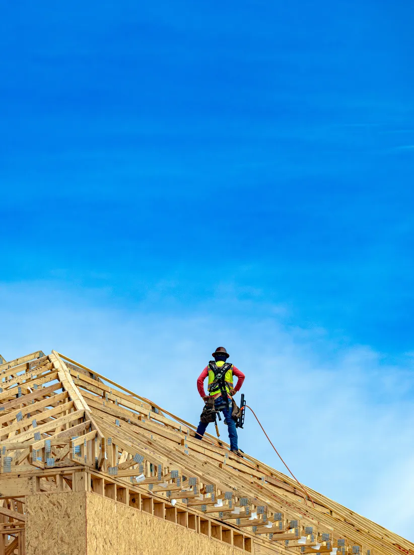 Los Angeles new home construction project with worker on wood roof framing by Super Contractor Pro