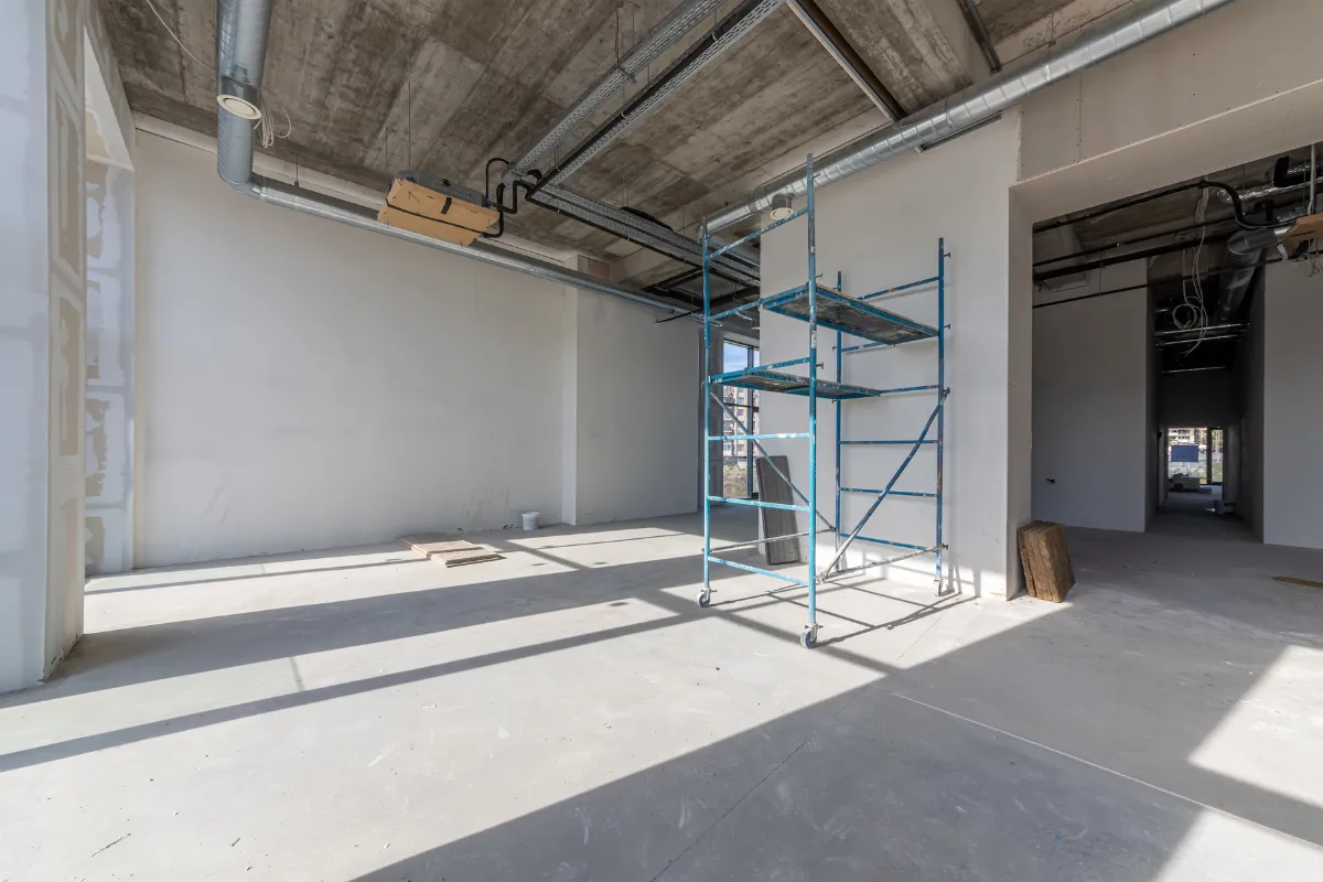 Commercial remodeling project in Los Angeles with open interior buildout, drywall work, exposed ceiling systems, and construction scaffold