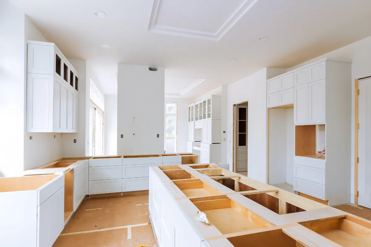 Kitchen remodeling in Los Angeles with custom white cabinets, large island framing, and unfinished countertop installation