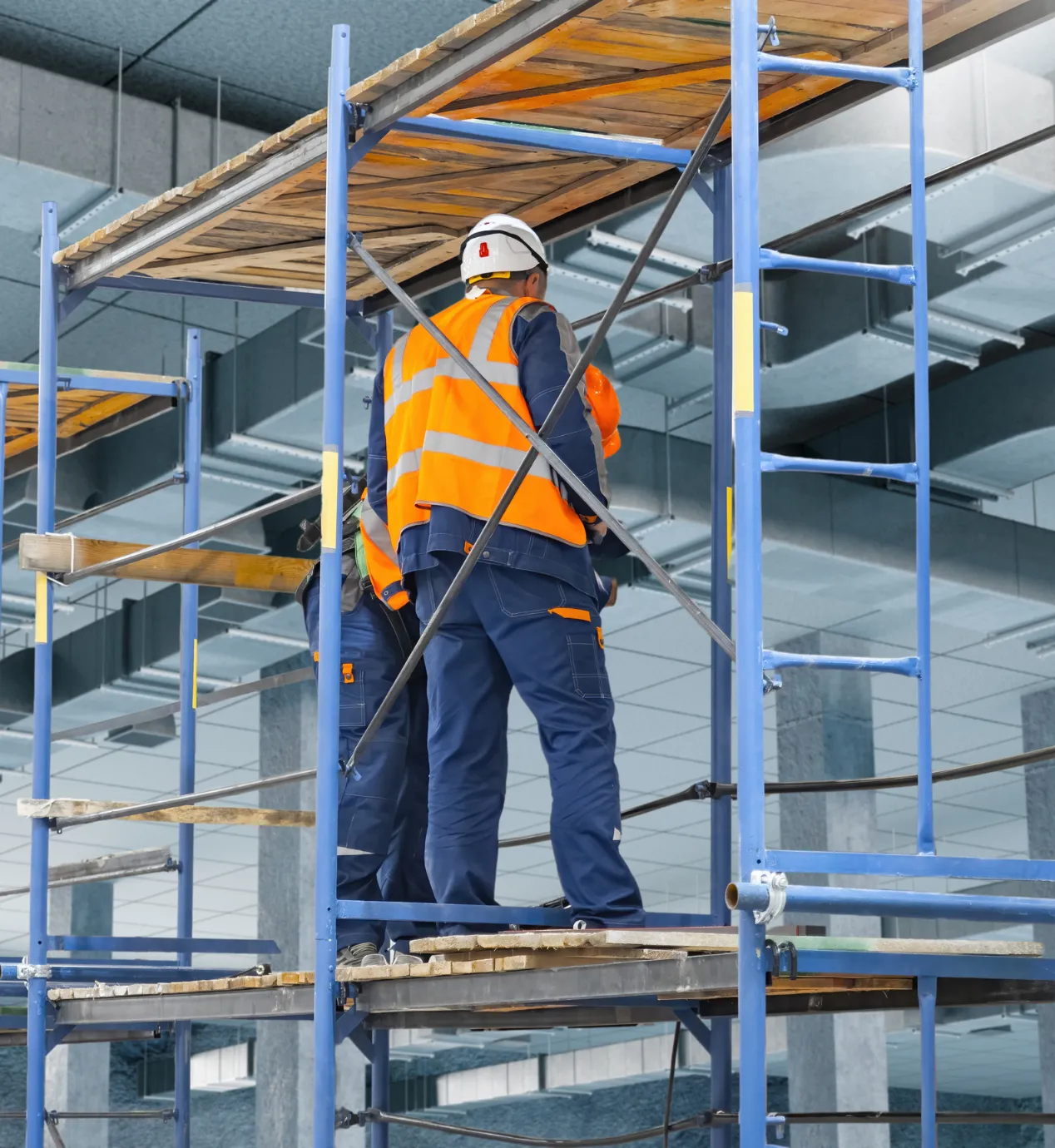 Los Angeles commercial remodeling project with contractors on interior scaffolding, ceiling work, and tenant improvement construction