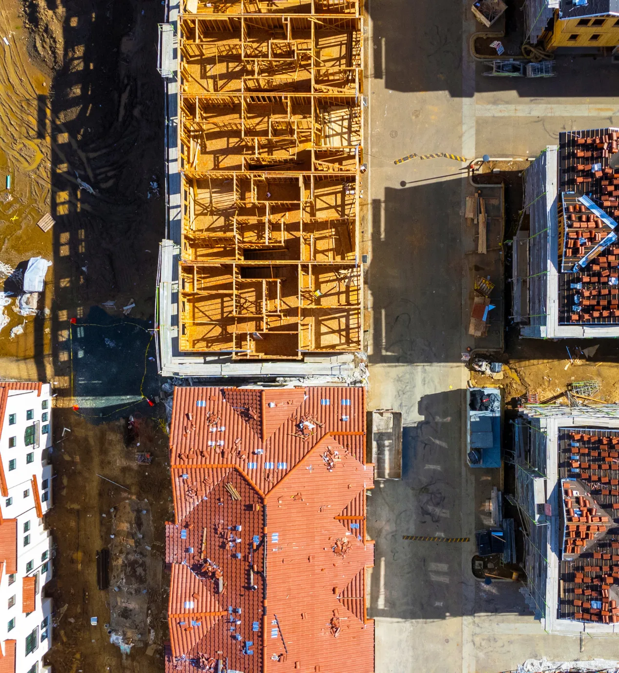 Los Angeles new home construction project with aerial view of residential framing, roofing installation, and multiple homes under construction